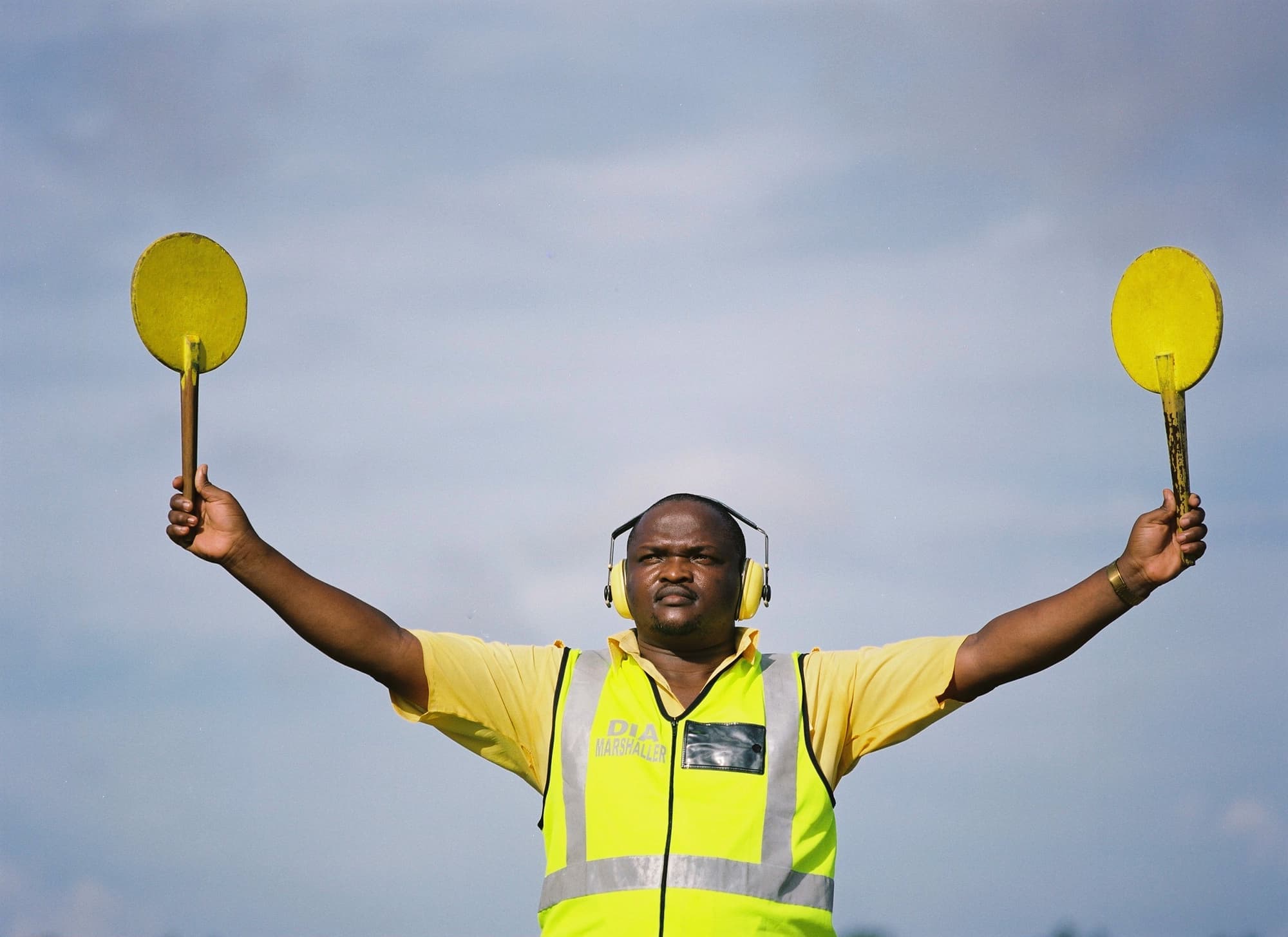 A man holding up two yellow round signs