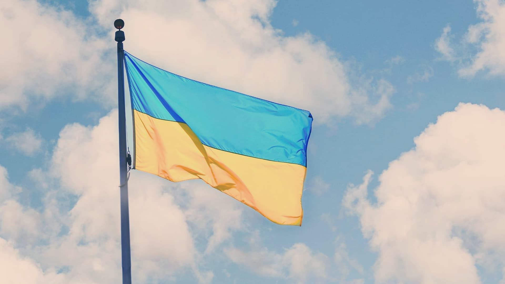 Ukraine flag on flagpole facing sky