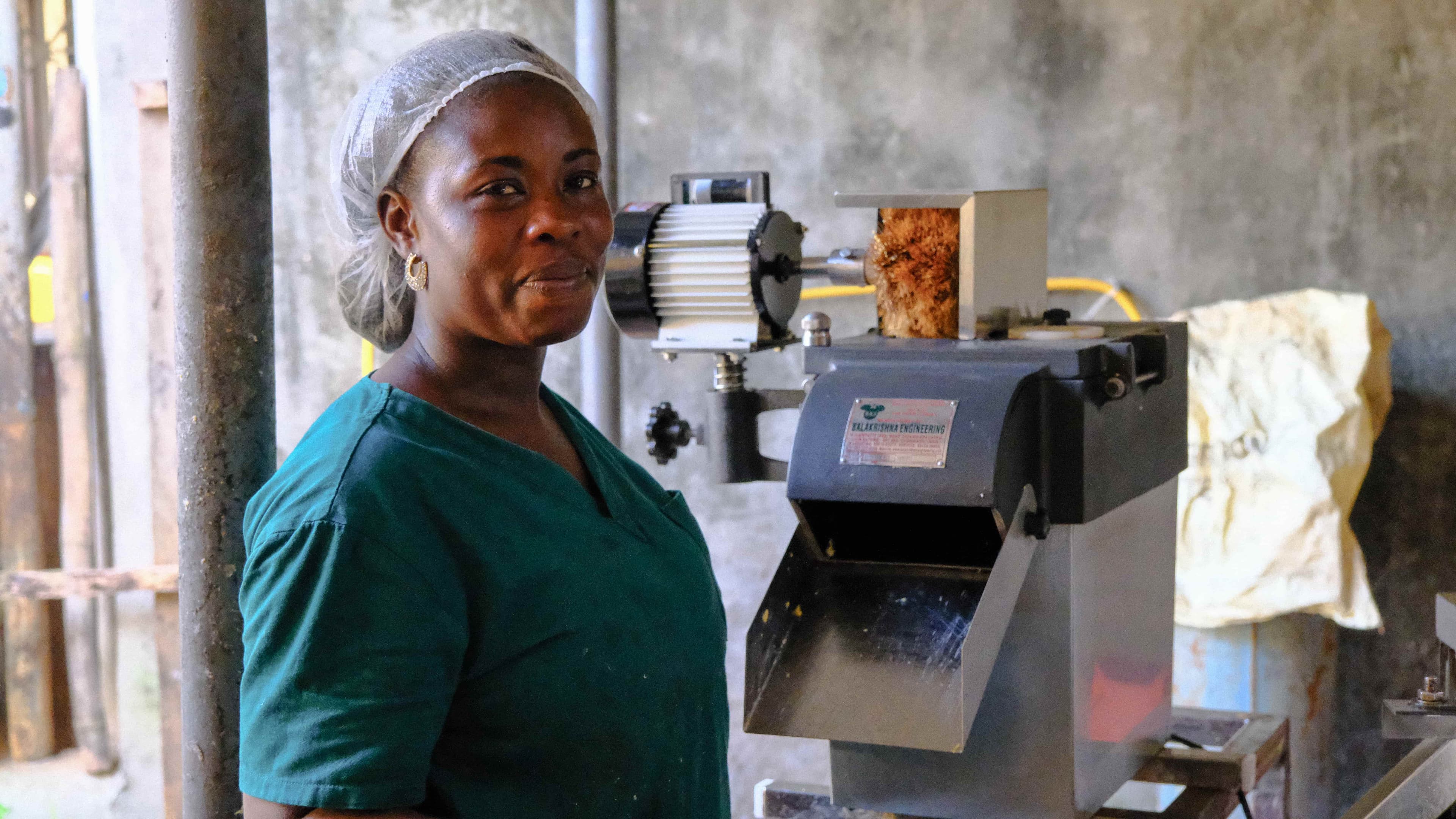 Woman standing with PPE at a machine