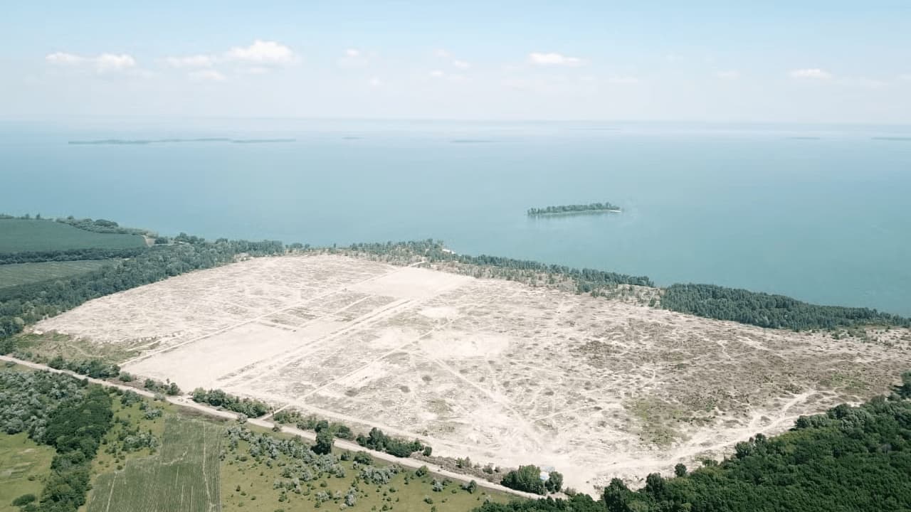 Aerial view of a deforested field by a sea
