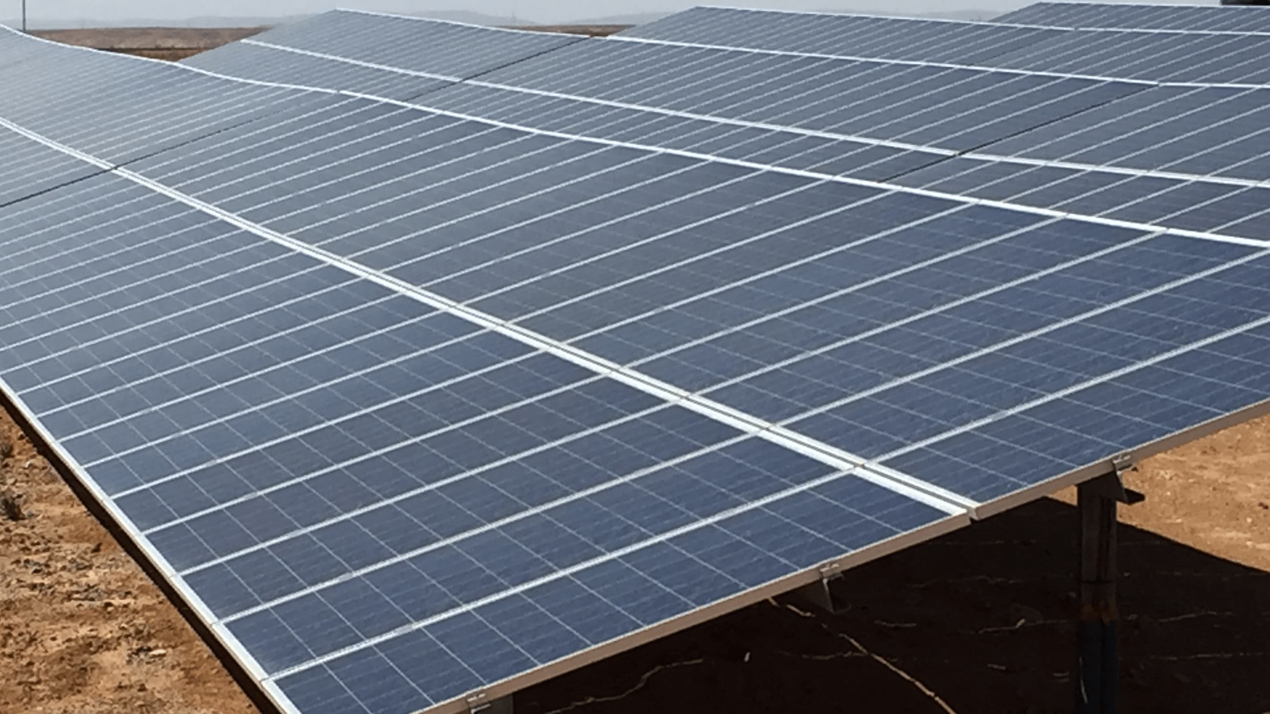 Solceller uppställda på grusplan
