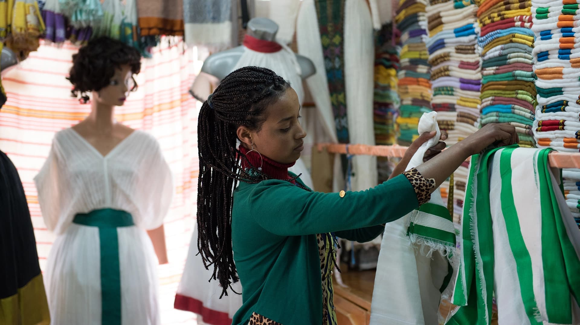 Woman hangs scarves in her shop