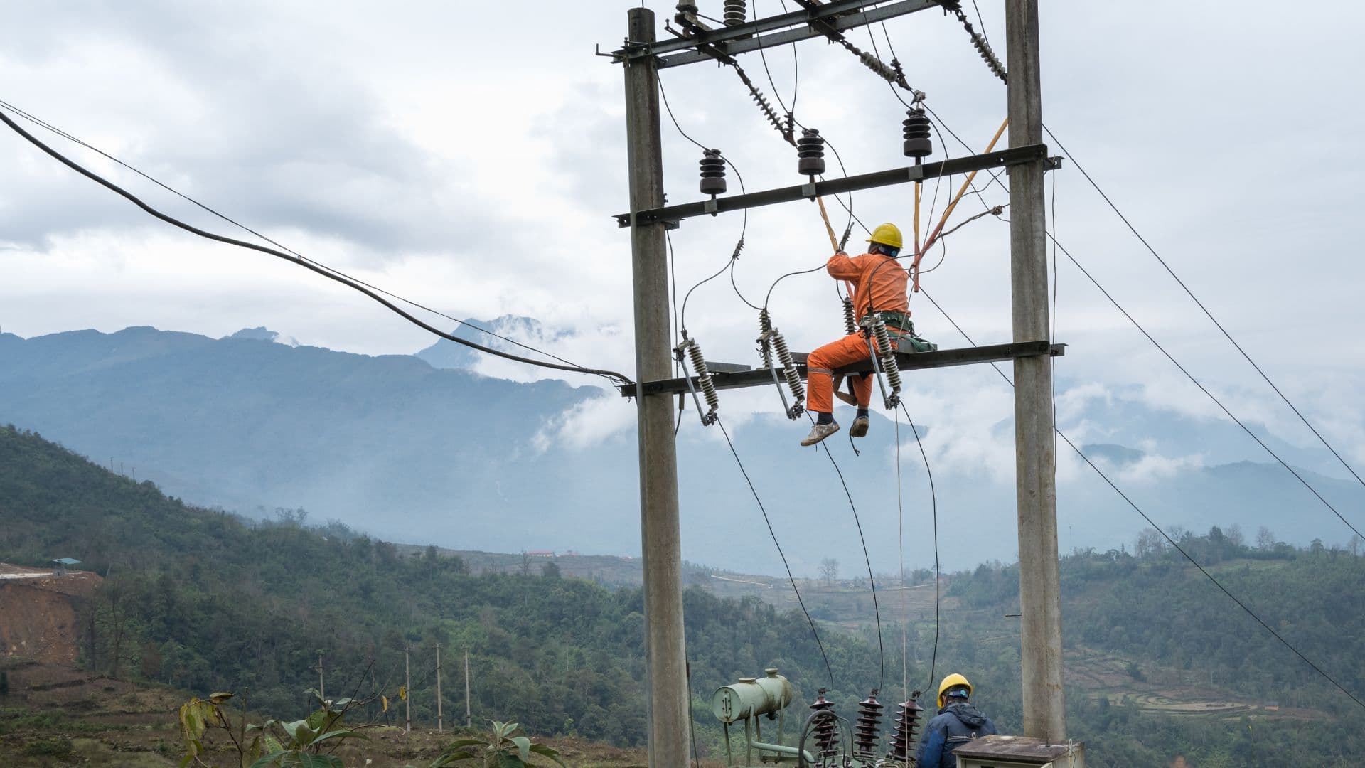 Man repairing a power cable high in the air