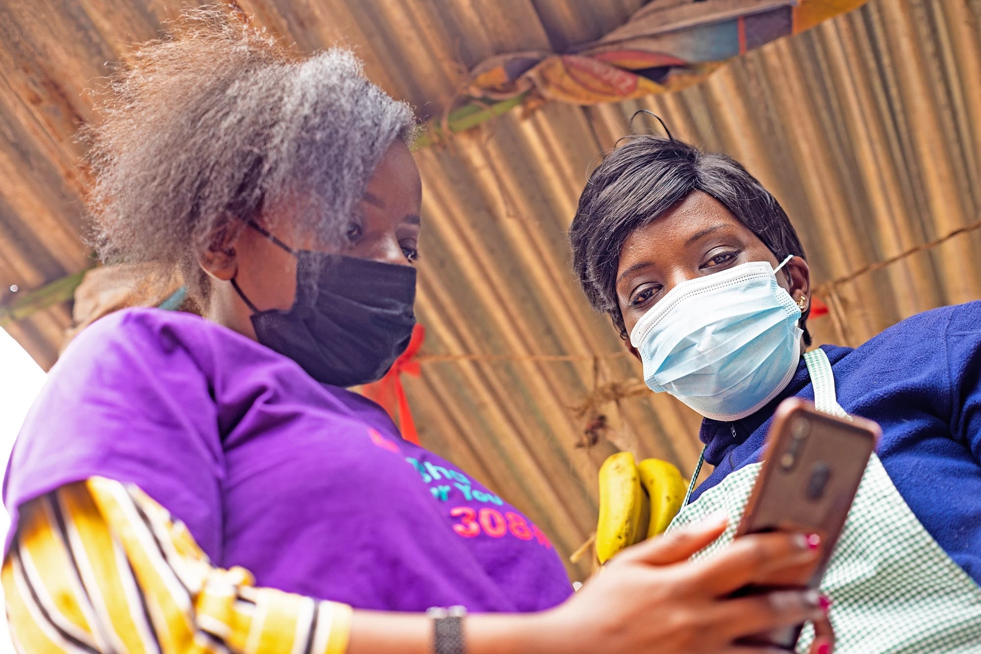 Two women looking down at a mobile phone