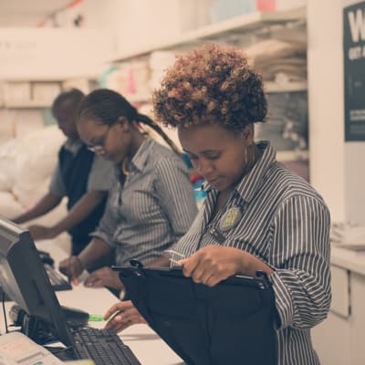 Employees inspecting clothes and typing on computers