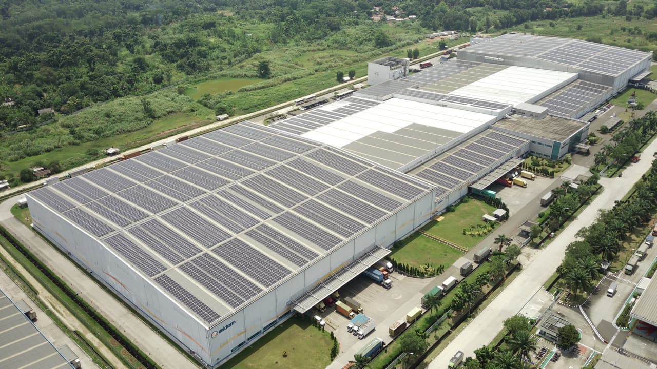 A drone photo of a warehouse with solar panels on the roof