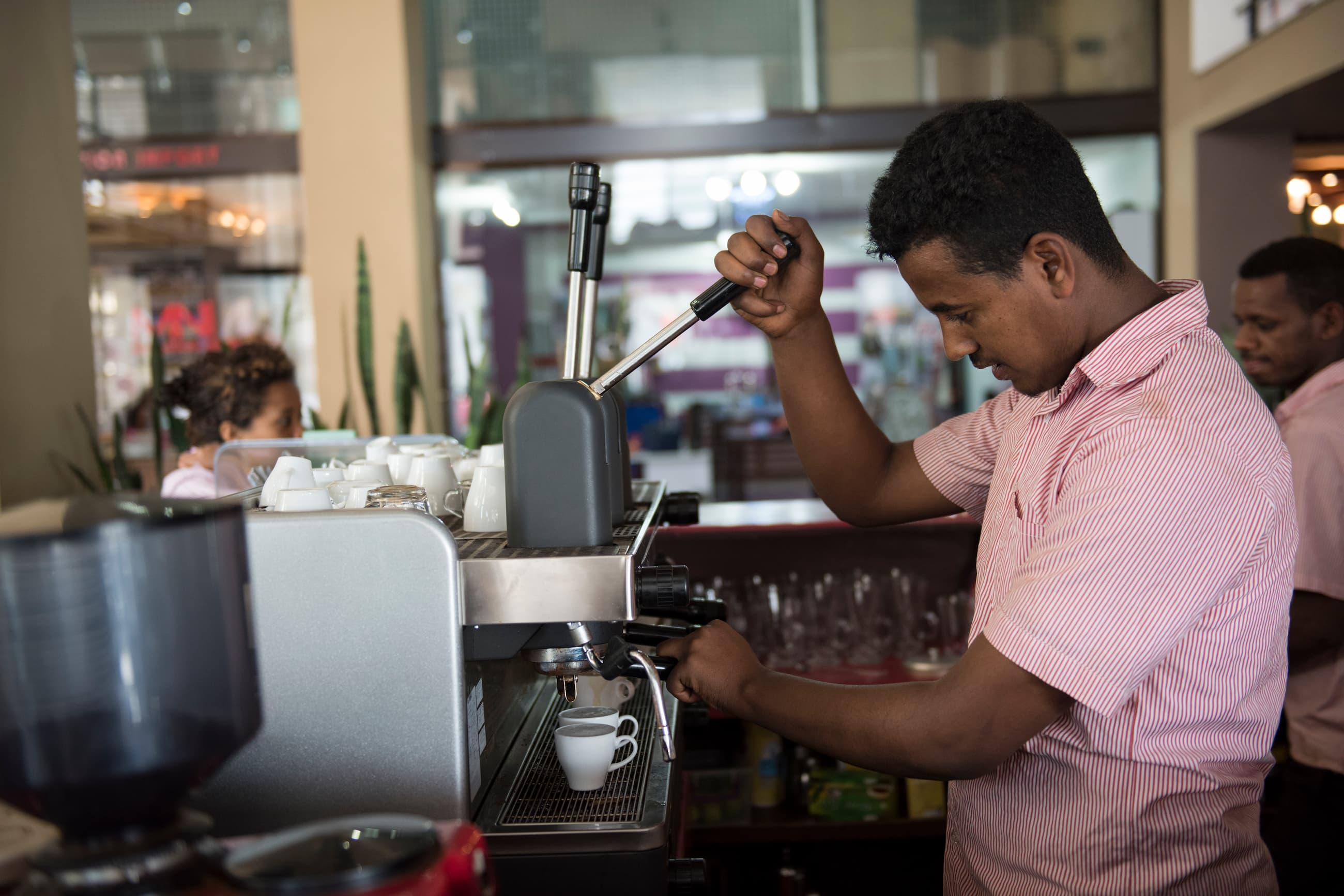Barista gör en kaffe vid en maskin