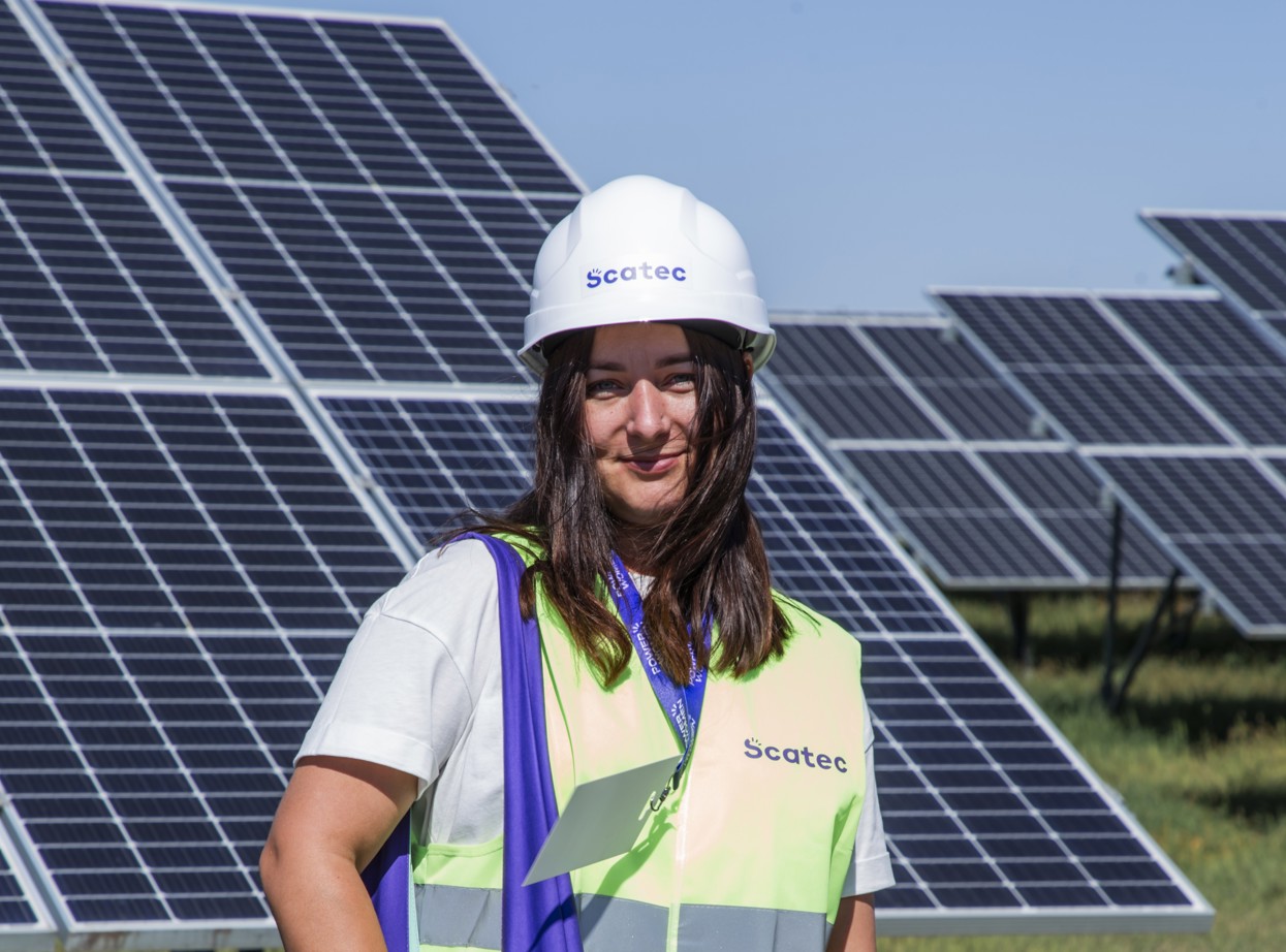 Woman in hard hat in a solar plant field