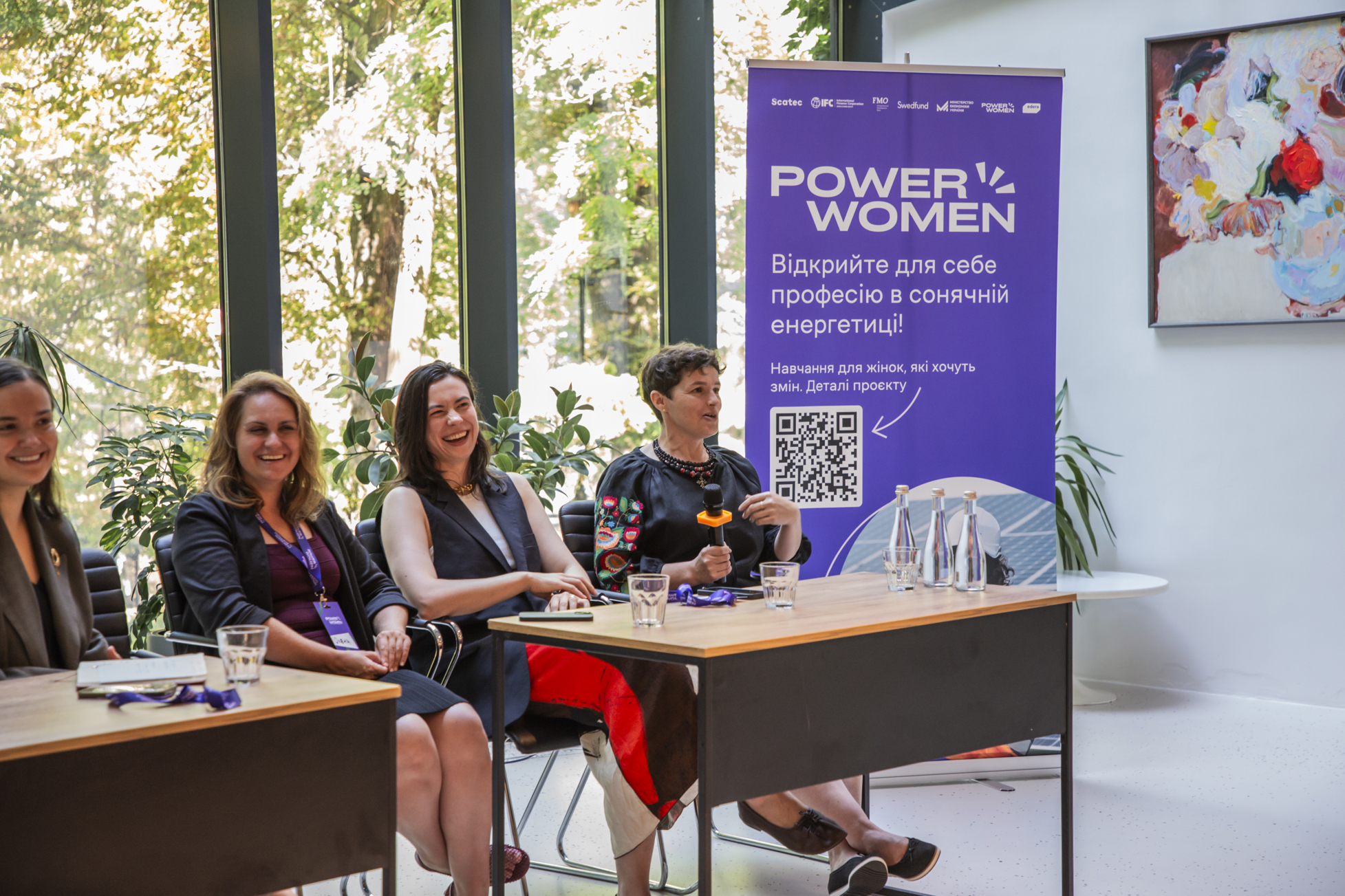 Four women in a panel in front of a Power Woman sign